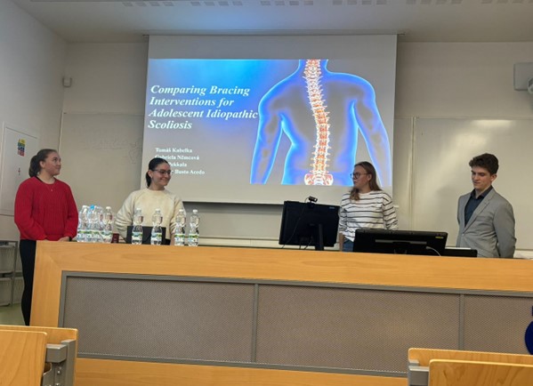 Students giving a presentation on the topic Comparing Bracing Interventions for Adolescent Idiopathic Scoliosis.